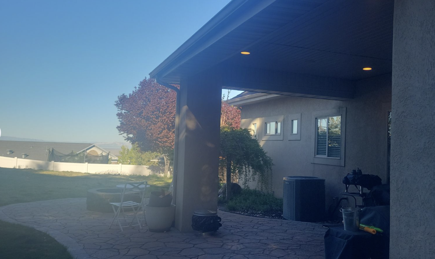 Completed stucco home exterior with covered patio, consistent color, and well-maintained finish in Utah