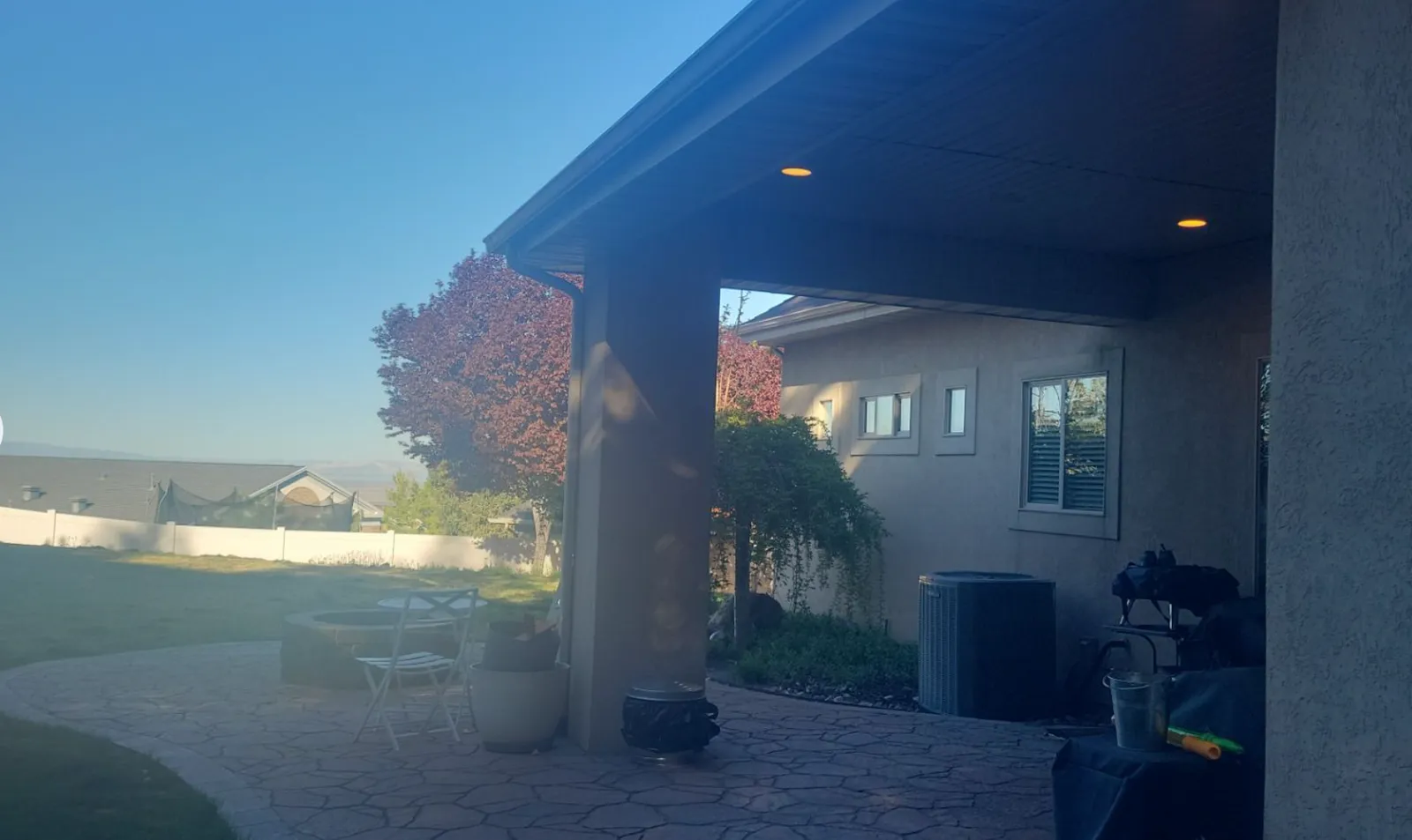 Completed stucco home exterior with covered patio, consistent color, and well-maintained finish in Utah
